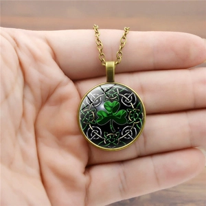 Vintage bronze pendant necklace with green shamrock pattern and glass cabochon