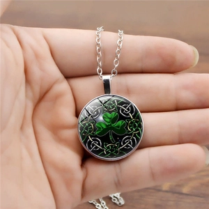 Silver pendant necklace with green clover and Celtic knot under glass dome