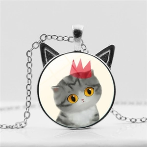 Close-up of cat ear necklace pendant with crown cat glass cabochon in silver finish