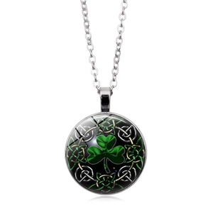 Close-up of glass pendant with green shamrock pattern and intricate Celtic knot border