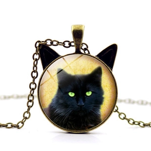 Detail of bronze necklace featuring cat ear pendant with a black cat glass cabochon