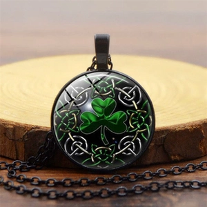 Detail of green shamrock glass pendant with Celtic knot on rustic wood slice