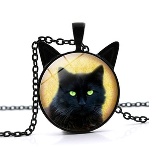 Detail of creative black cat ear pendant with glass dome and bright green eyes