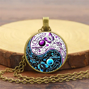 Macro view of vintage Yin Yang butterfly glass pendant on rustic wood surface