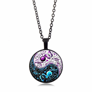 Macro shot of Yin Yang butterfly glass pendant with purple and blue fluorescent details