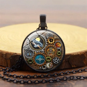 Détail du pendentif steampunk avec engrenages mécaniques et motif de corbeau noir