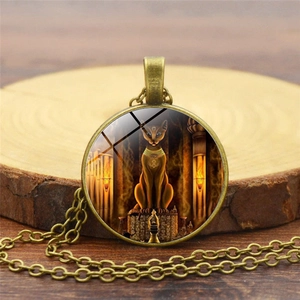 Detailed macro of vintage bronze Bastet Egyptian cat god pendant with glass cabochon