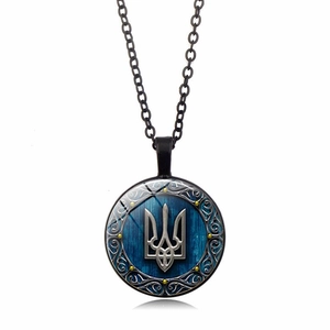 Macro detail of Ukraine trident emblem on glass cabochon pendant with silver metal bezel