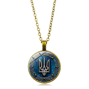 Macro shot of bronze Trident necklace with wood texture and glass dome pendant