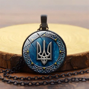 Close-up of Ukraine Trident coat of arms pendant with blue wood grain texture base