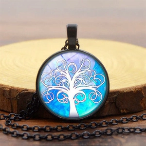 Detalle de colgante del Árbol de la Vida con fondo cósmico sobre base de madera