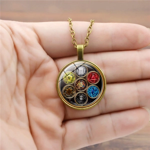 Vintage bronze Yoga Seven Chakra pendant necklace held in hand with colorful gemstones
