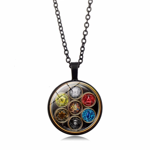 Macro detail of the Seven Chakra pendant featuring vibrant symbols on a black metal base