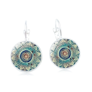 Detailed close-up of mandala patterns on silver glass dome earrings with reflections