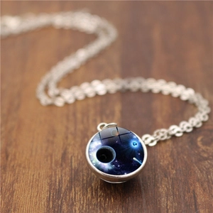 Macro d'un pendentif lune double face avec globe galaxie sur une surface en bois