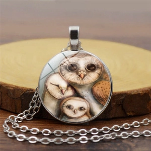 Detailed macro of vintage owl pendant featuring glass gem and silver alloy chain link