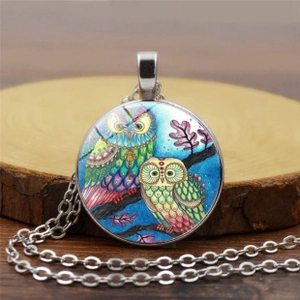 Macro detail of the vintage glass cabochon pendant with colorful owl illustration on wood