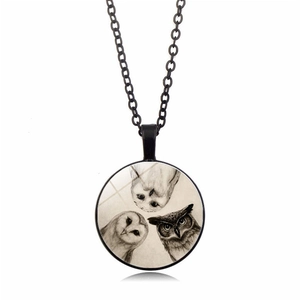 Macro detail of three owls vintage art pendant with glass cabochon and black chain