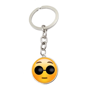 Close-up of a silver keychain featuring a yellow emoji pendant with cool sunglasses
