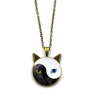 Collier vintage en bronze avec pendentif chat Yin Yang en verre sur fond blanc