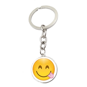 Macro detail of silver keychain with a yellow glass dome emoji pendant