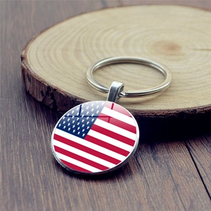 Classic metal keychain featuring an American flag glass dome pendant on wooden background