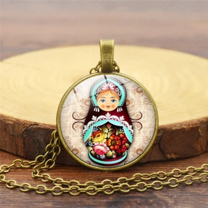 Détail du collier avec pendentif rond en bronze et motif poupée russe sur support en bois