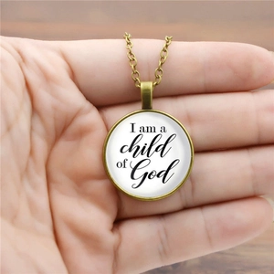 Detailed close-up of a bronze glass cabochon pendant with I am a child of God text