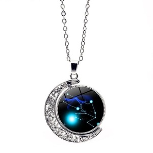 Detail of silver crescent moon necklace with Taurus zodiac pendant and starry glass dome