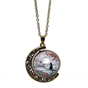 Vintage bronze moon necklace featuring a black cat sitting on a branch under moonlight