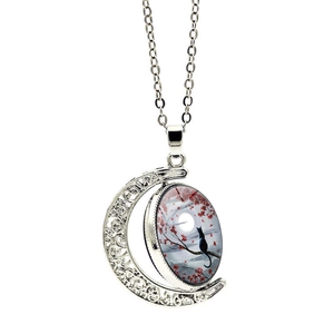 Rotating crescent moon necklace with a cat silhouette under moonlight on a silver chain