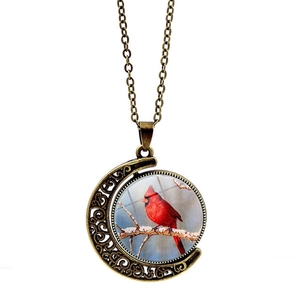 Vintage bronze spinning moon necklace with red cardinal bird design on a winter branch
