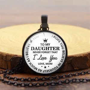 Détail du pendentif rond en cristal avec message pour sa fille sur un support en bois