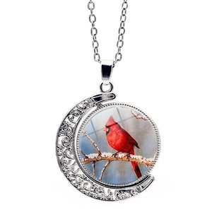 Rotating crescent moon pendant necklace with red cardinal bird illustration on white base