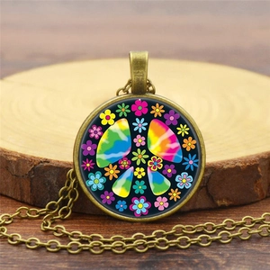 Macro view of rainbow peace sign flower pendant on vintage bronze chain over wood