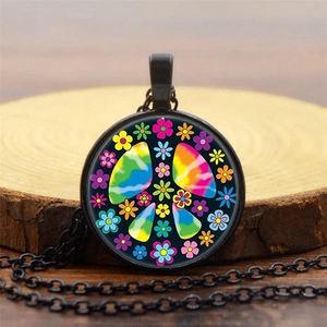 Macro detail of peace sign pendant with tie-dye patterns on a wooden surface