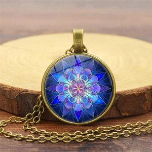 Close-up of mandala flower glass dome pendant on a rustic wood slice background
