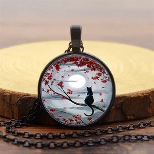 Macro shot of a black cat moonlit pendant on a rustic wood slice with a maple leaf design