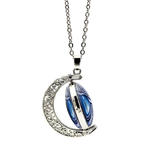 Macro shot of retro hollow crescent moon pendant with blue eye stone and filigree details