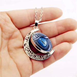 Gothic moon pendant necklace featuring a blue dragon eye gemstone in silver hollow frame