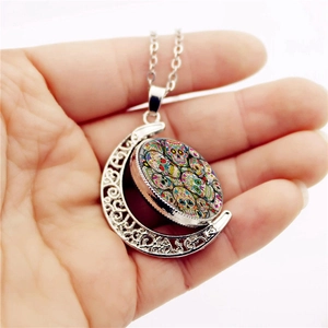 Silver crescent moon necklace with colorful sugar skull pendant held in hand