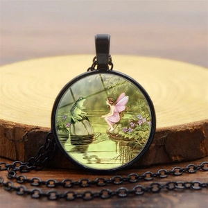 Macro di una collana vintage fata rana nera su uno sfondo in legno strutturato