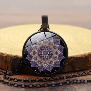 Macro del ciondolo a fiore mandala in vetro con intricati motivi viola e verdi