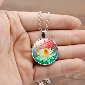 Detailed close-up of a glass gemstone pendant featuring a white lotus flower art design