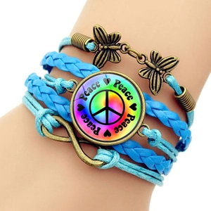 Detailed close-up of multilayer braided leather bracelet with peace sign and butterfly