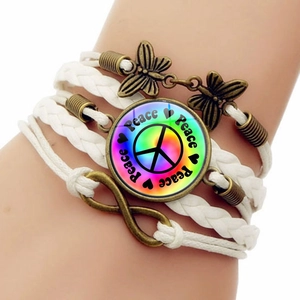 Detail shot of multi-layer braided bracelet with peace sign gem and bronze butterfly charms