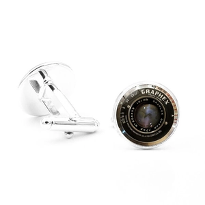Macro shot of silver cufflinks featuring retro camera lens details and aperture markings