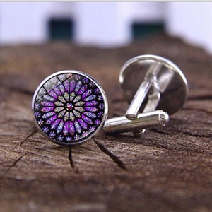 Elegant men silver cufflinks featuring gothic rose window glass design on wooden background