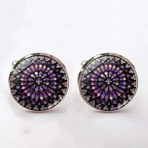 Macro detail of silver-tone cufflinks featuring a Notre Dame rose window mosaic design