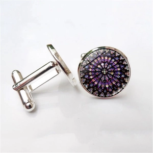 Detailed macro view of silver-tone round cufflinks with colorful rose window glass pattern